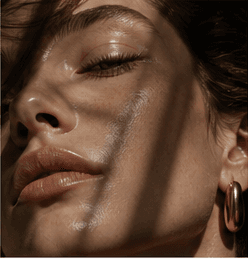 Beauty close-up with luminous skin and directional shadow.
