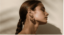 Beauty portrait with sculptural gold earrings.